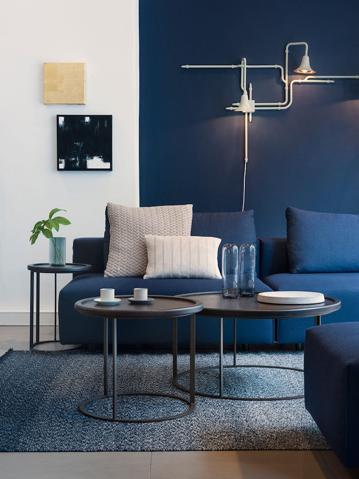 déco appartement, mur peint en blanc et bleu, table basse en noir, canapé en bleu foncé, lampe industriel blanche