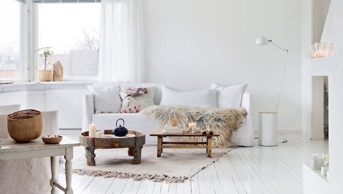 meuble scandinave, panier en fibres végétales, plaid en faux fur, coussins décoratifs en blanc, rideaux longs en blanc