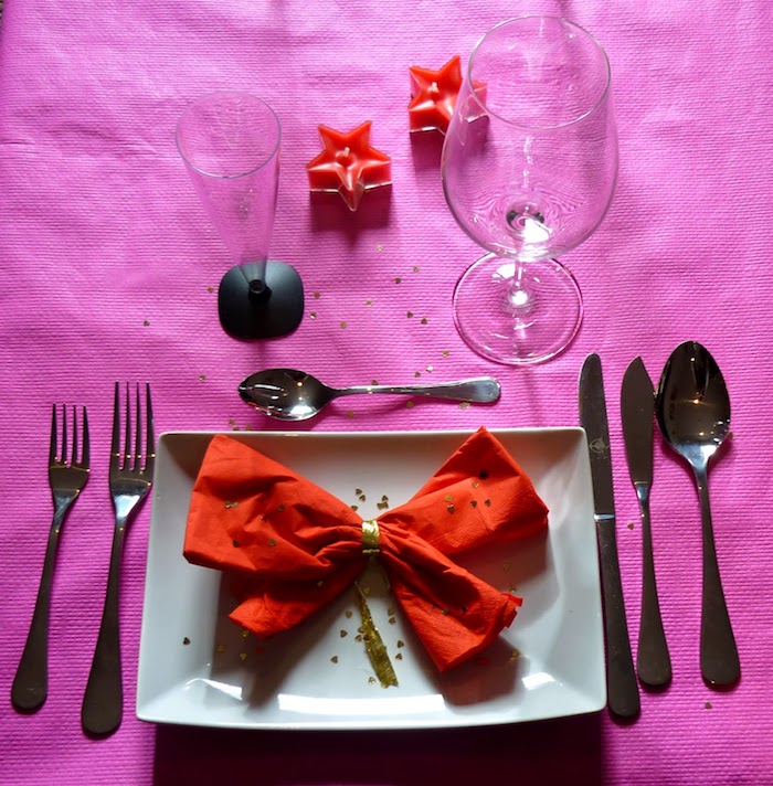 arrangement de table de fête, faire un ruban origami avec serviette en tissu rouge, nappe de table violette