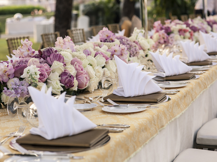 arrangement de table mariage, nappe beige à motifs dorés, bouquets de roses, serviette origami blanche