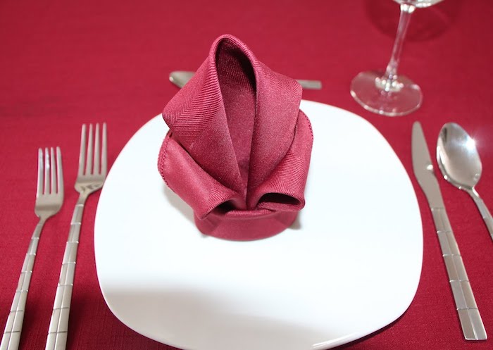 arrangement de table élégant, technique de pliage serviette en tissu rouge, nappe de table rouge