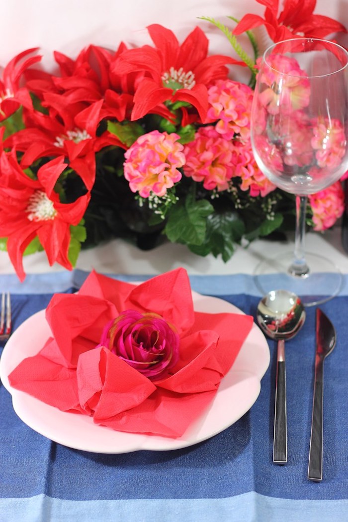 pliage serviette fleur, nappe de table rectangulaire en bleu, serviette origami rouge avec petite rose au centre