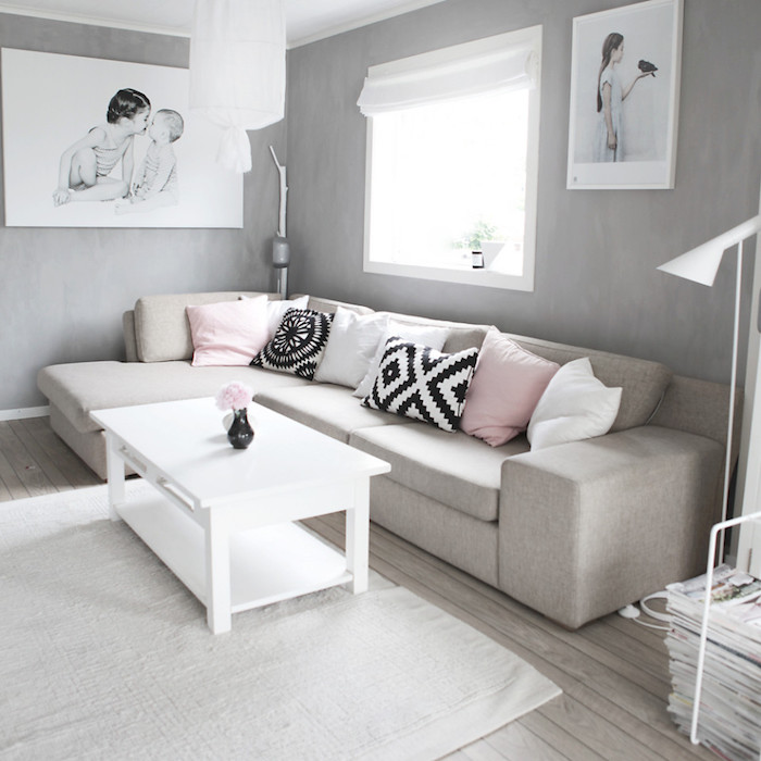 mobilier scandinave, suspension luminaire blanche, murs peints en gris, canapé d'angle beige avec coussins décoratifs, table blanche