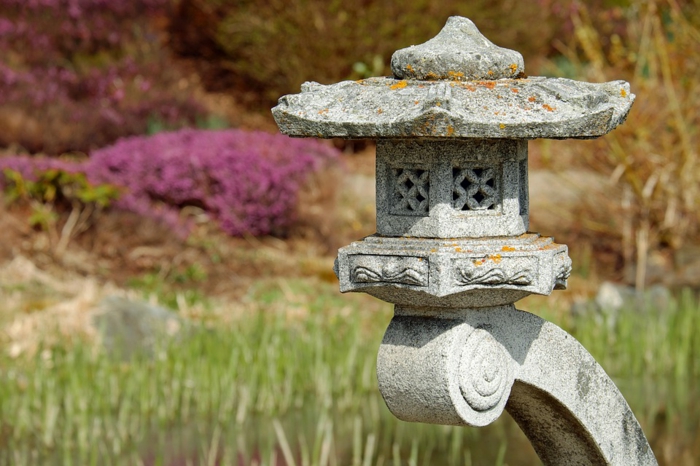 déco de jardin zen, idée d'élément essentiel à la décoration japonaise, une lanterne lampe en pierre, paysage envahi par la vegetation