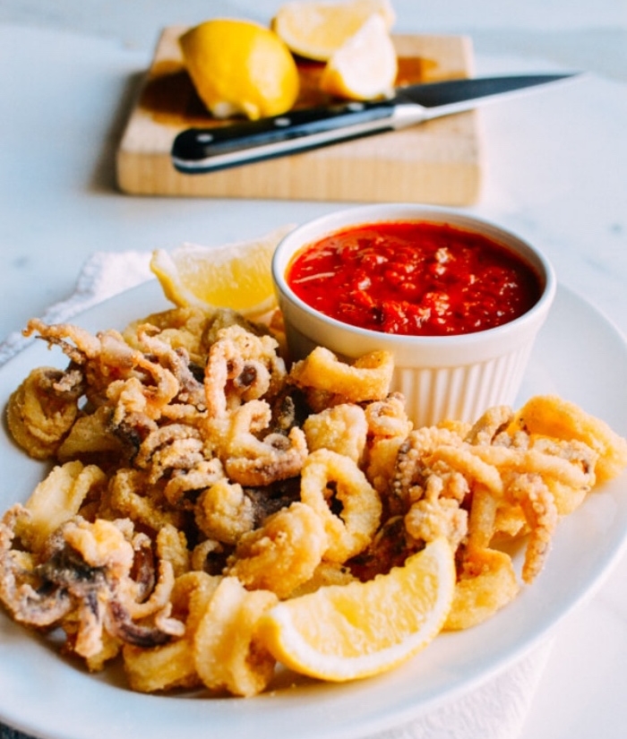 idée de tapas facile, fruits de mer, tentacules de poulpe et calmars frites servis avec de al sauce marinara