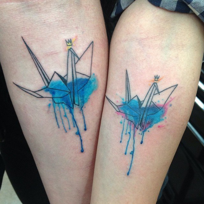 deux grues origami majestueuses tatoués sur l'avant-bras, idée originale pour un tatouage aquarelle de couple