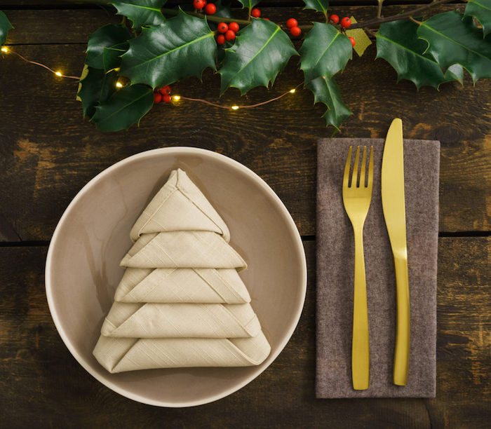 sapin en serviette tissu beige, arrangement de table de Noël, guirlande lumineuse et branchette verte artificielle