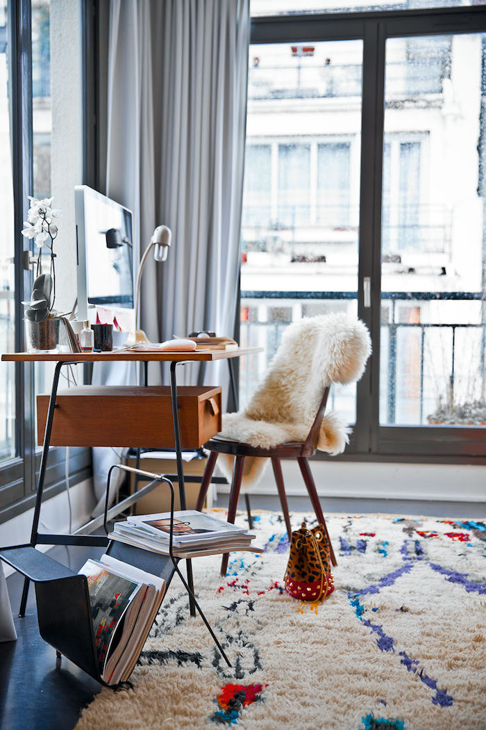 décoration appartement, bureau en bois, étagère magazine, rideaux longs et gris, tapis blanc en faux fur, chaise en bois avec housse blanche