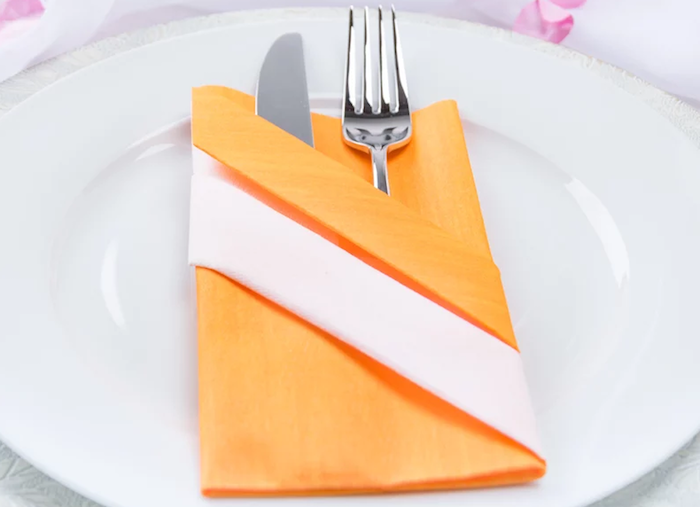 decoration de table, couverts de table, serviette pliage origami en orange et blanc, assiette ronde et blanche