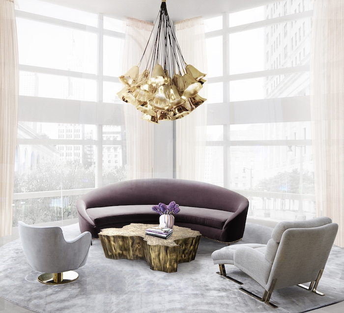 lampe cuivre, tapis en velours gris, fenêtres surdimensionnés, rideaux longs en beige, plafond blanc, canapé en velours violet