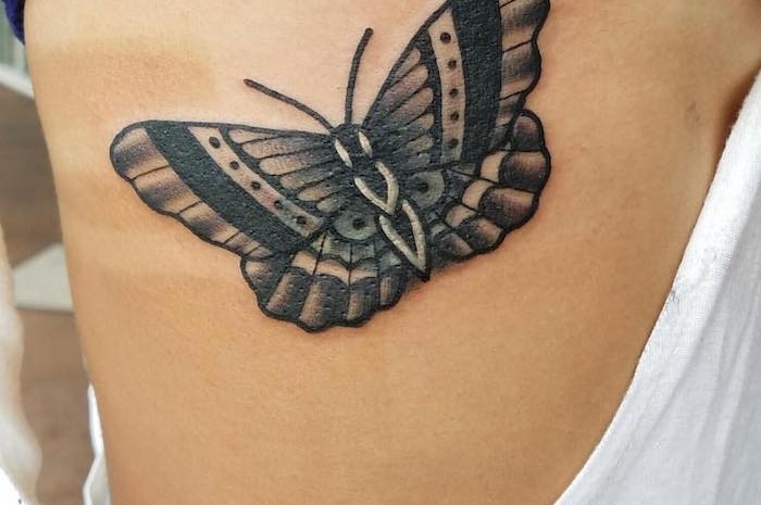 tatouage symbolique, dessin sur le corps féminin, tatouage à design papillon noir