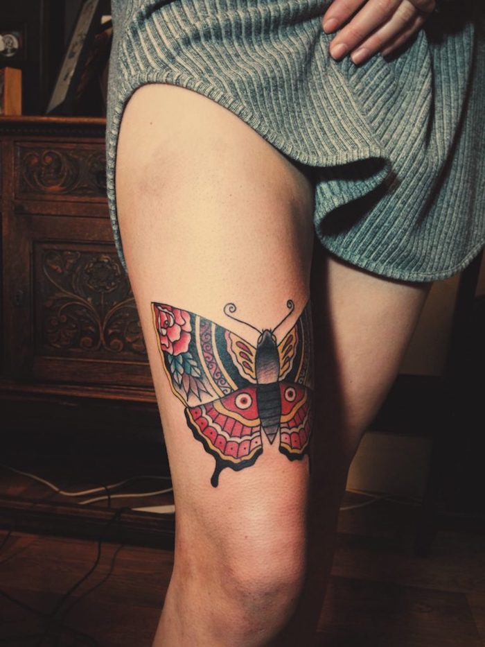 tatouage couleur, idée dessin en encre sur la peau, tatouage papillon avec ailes à motifs floraux rouges