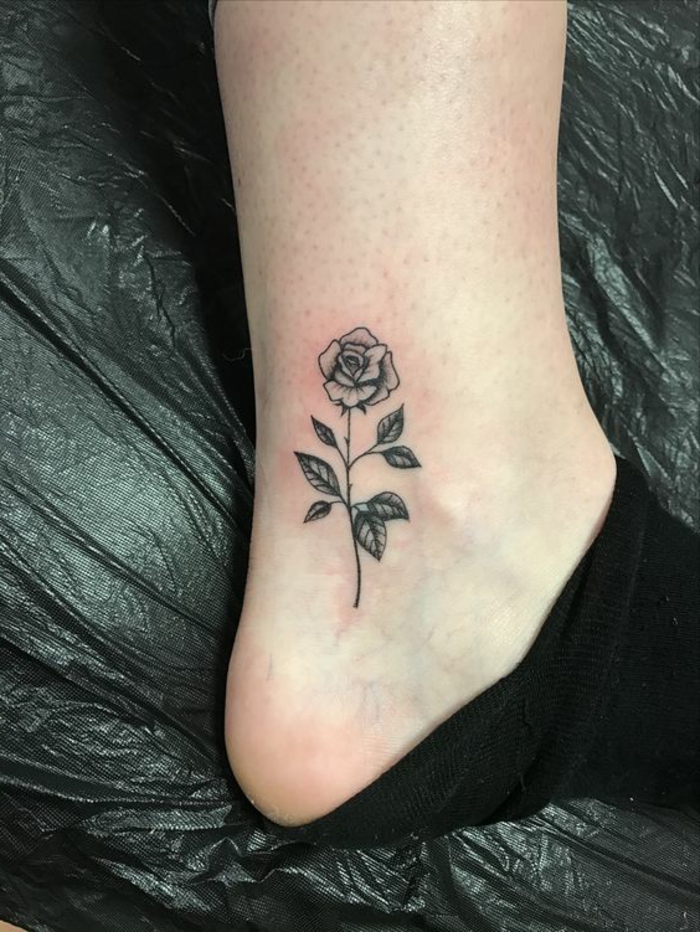 fleur tatouage, petite rose tatouée à la cheville, rose fleurie en encre noire