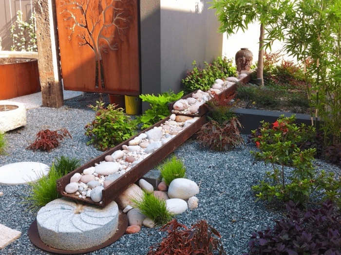 une rivière en pierre et sol en gravier, arbustes et bambou, idée amenagement jardin zen minimaliste