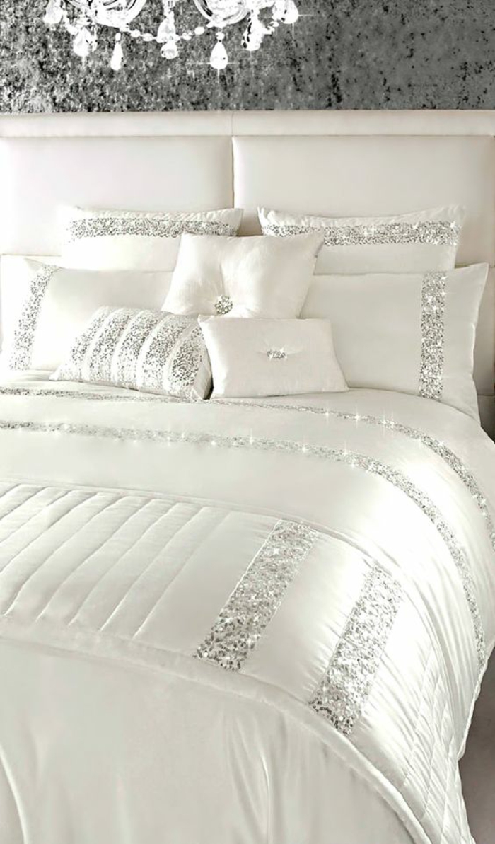 peinture gris perle lit en blanc aux bandes décoratives en gris pailleté avec un grand lustre brillant