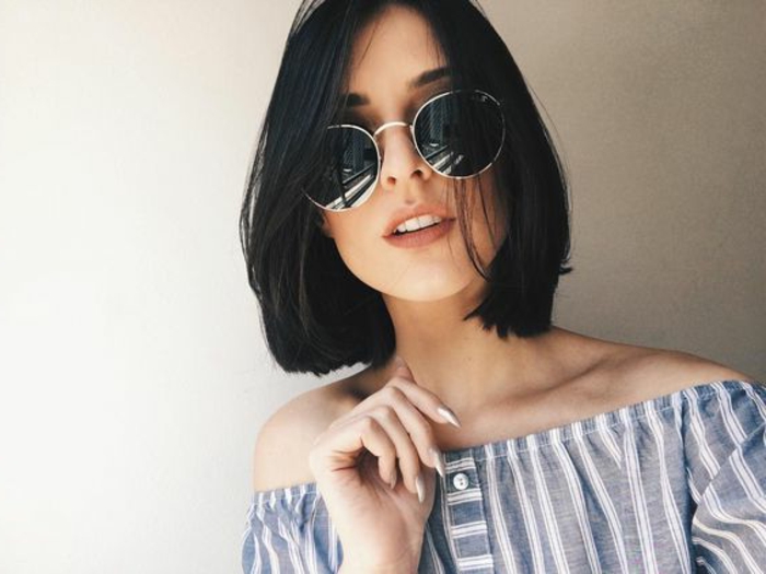 carré court classique sur des cheveux couleur noire, lunettes de soleil rondes, tenue été
