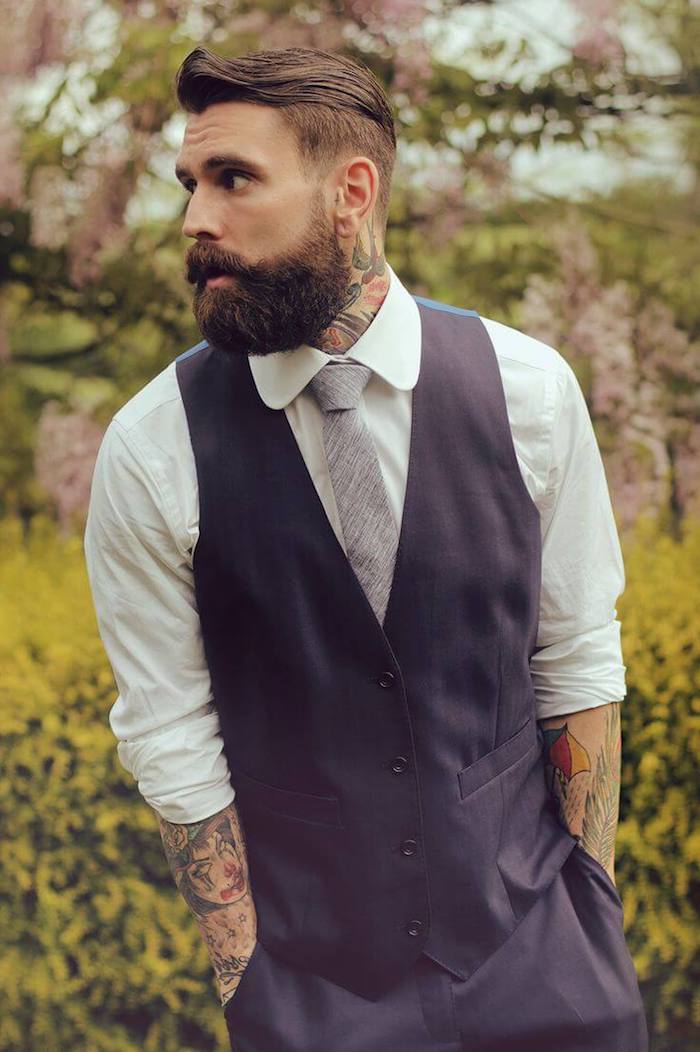 idée-coupe-de-cheveux-chemise-blanche-cravate-grise-pantalon-bleu-foncé-tatouage-homme-en-couleurs coiffure homme tendance, chemise blanche avec cravate gris et blazer noir sans manches, tatouage en couleurs pour homme