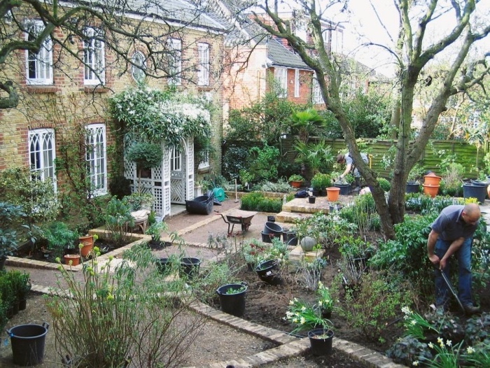 aménager son jardin, maison style cottage anglais, un jardin avec plusieurs carrés végétalisés à différente hauteur, entrée en arc fleuri, arbres et fleurs