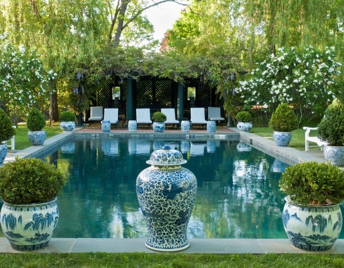 idee amenagement jardin avec une grande piscine, entourée de gazon, vases style bord de mer, avec des buis dedans, plusieurs chaises longues, brise-bue
