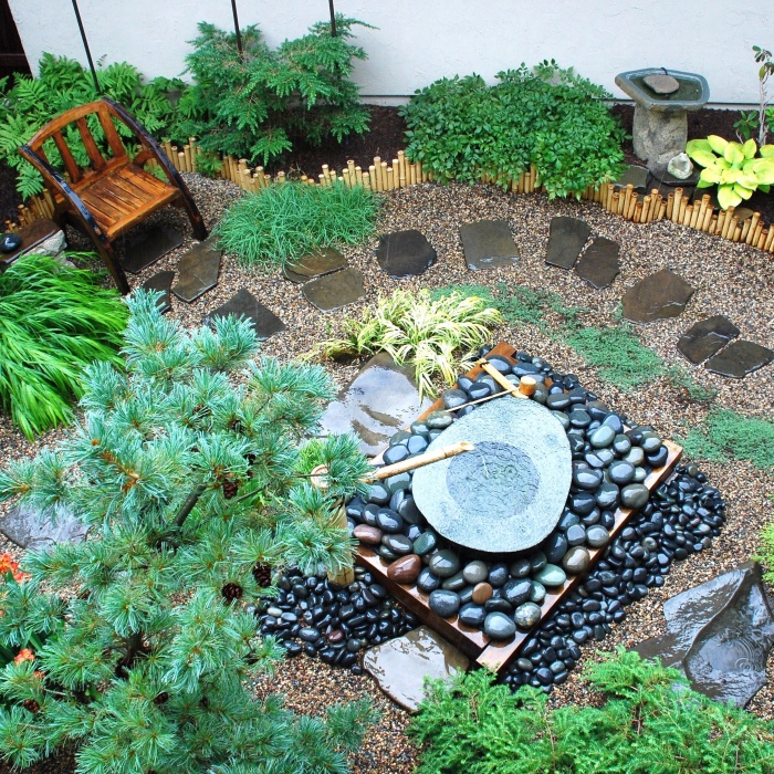 amenagement jardin zen japonais exterieur, galets, pierres, source d eau, chemin de pierres, arbustes et arbres, chaise en bois