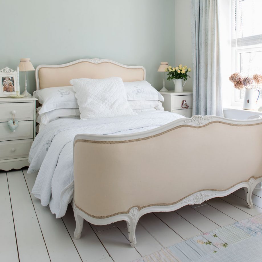 shabby chic lit beige, linge de lit blanc, tables de nuit blanches, parquet blanchi, mur couleur vert pastel clair, bouquets de fleurs