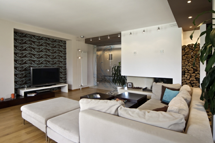 idée deco salon moderne, grand sofa modulable, sol aspect bois, plusieurs lampes installées au plafond, range-bûche déco