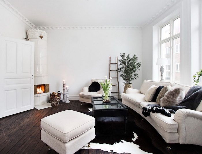 style scandinave, canapé blanc avec coussin en faux fur, cheminée blanche au coin, échelle décorative en bois