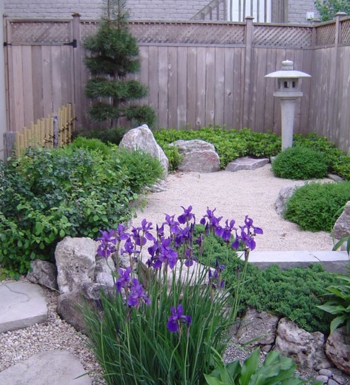 idée de petit coin jardin zen japonais dans la cour, sablier avec des pierres, arbustes et plantes couvrantes sol, fleurs élégants