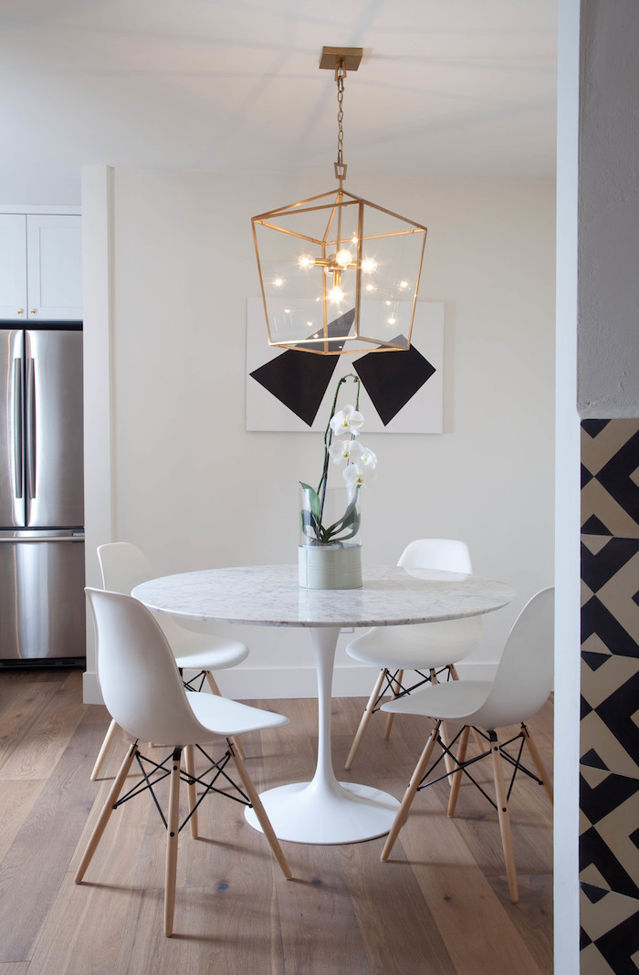 deco moderne, frigo gris, table ronde en marbre, peinture blanc et noir, suspension luminaire en cuivre, sol en bois