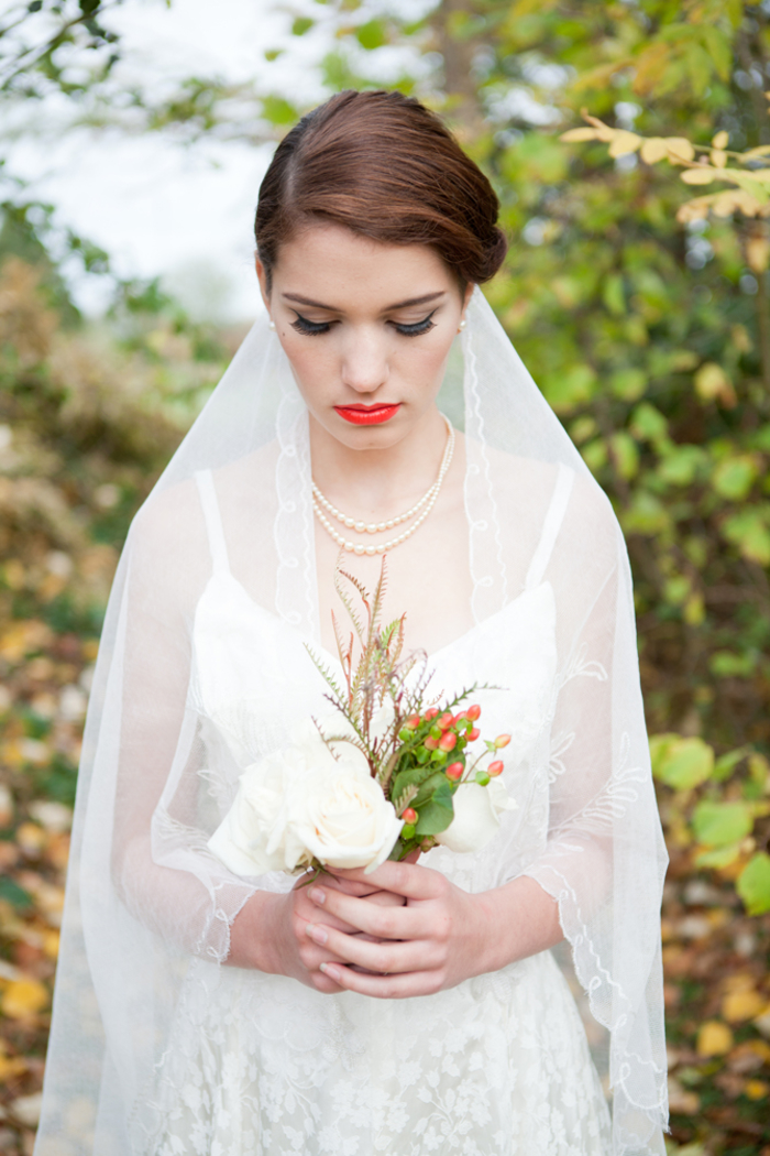 un look de mariage à inspiration vintage avec un voile conservatif modèle mantille et un rouge à lèvres rouge orangé