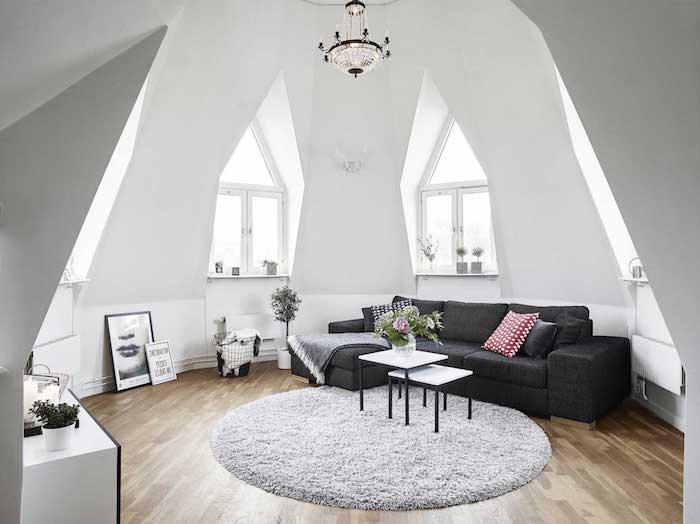 deco salon style scandinave, canapé noir avec coussins décoratifs, tapis blanc moelleux, murs peints en blanc
