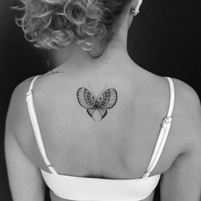 dessin tatouage, photo blanc et noir, coiffure cheveux attachés, piercing oreille, tatouage papillon sur le dos