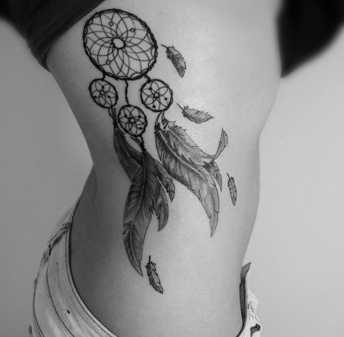 tatouage femme, dessin en encre sur le corps féminin, tatouage à design attrape rêve avec plumes