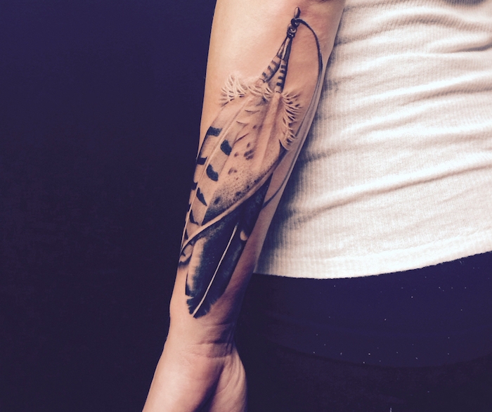plume tatouage, tenue en débardeur blanc et pantalon noir, tatouage sur le bras en design plumes