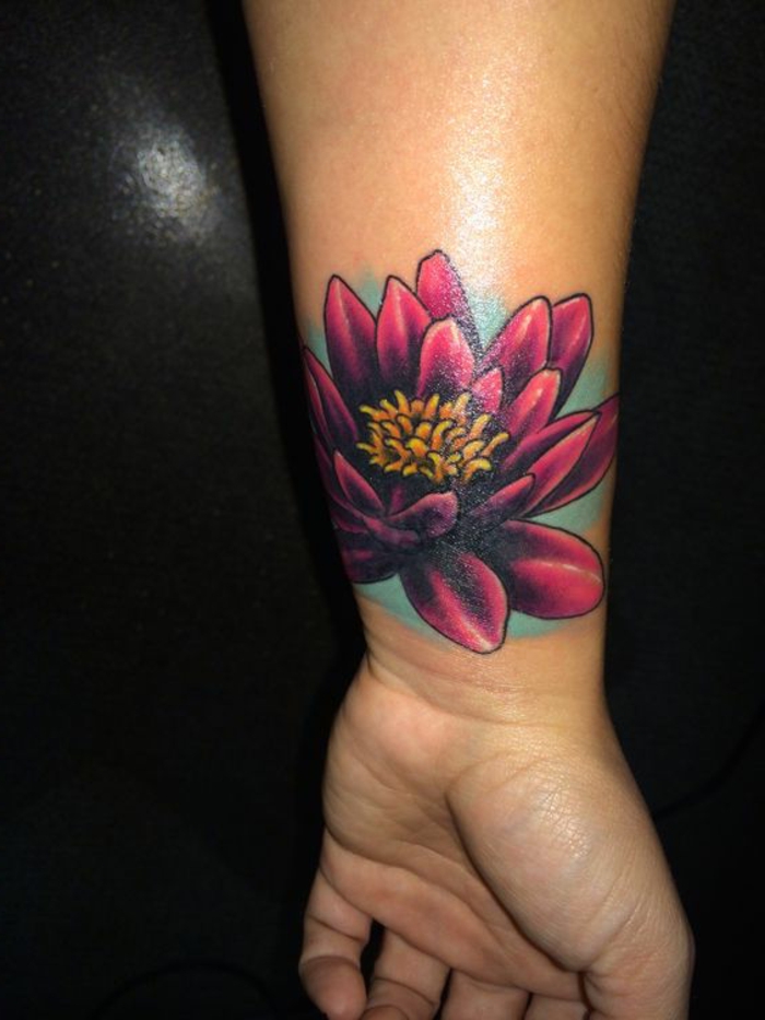 modele tatouage femme, tatouage en bleu et lilas, lotus au poignet