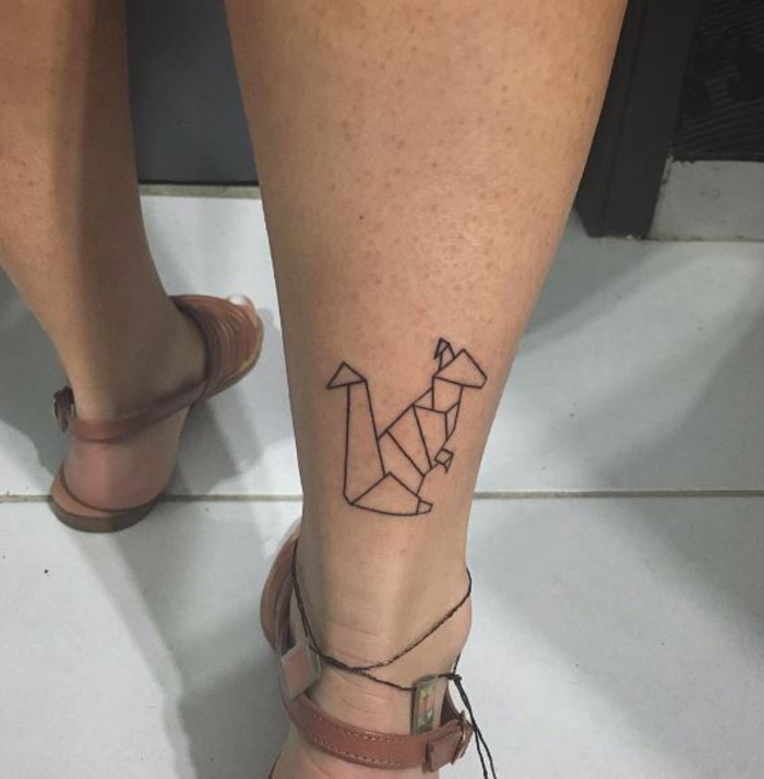 un tatouage géométrique en forme de kangourou au design simple en base de la jambe