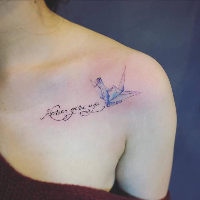 un tatouage minimaliste grue en origami poétique et inspirant associé à un tatouage calligraphie