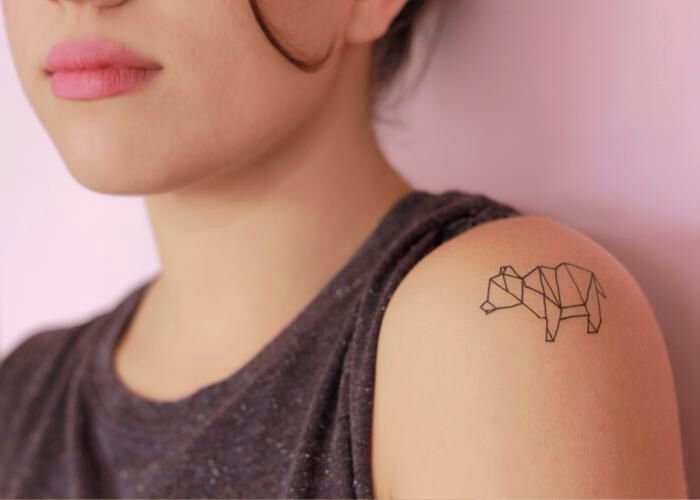 un tatouage minimaliste animalier aux lignes géométriques évoquant l'art de l'origami