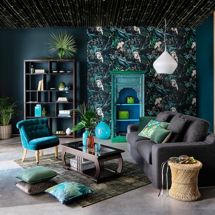 tissu tropical, bibliothèque en bois marron, pot à fleur en fibre végétal, meuble vintage peint en turquoise, lampe suspendue en blanc