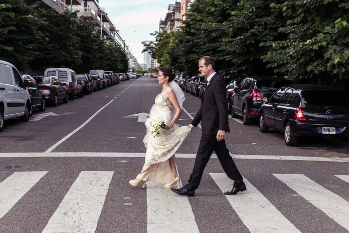 photo artistique de couple de mariés qui traverse un passage piétons 