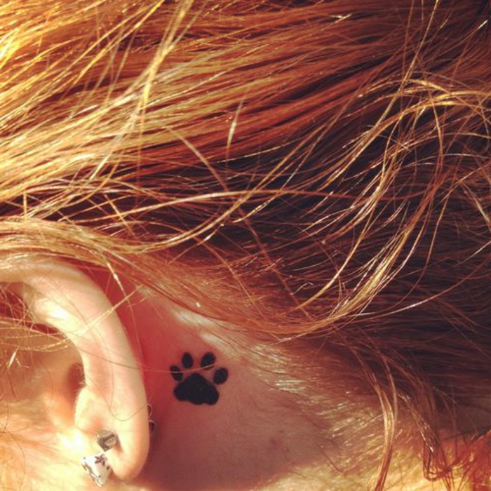 patte de chat tattoo, tatouage derrière l'oreille avec de l'encre noire