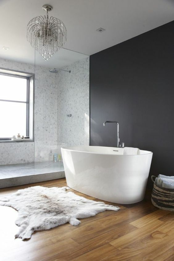 gris perle salle de bains avec baignoire blanche ovale lustre baroque au plafond parquet nuancé en PVC