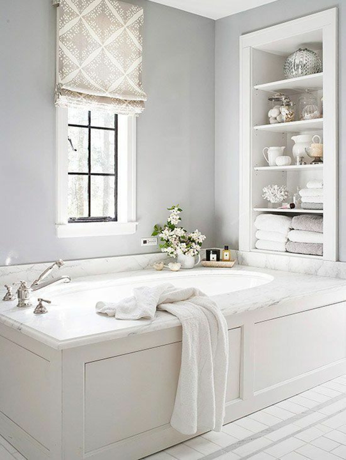 petites salles de bains avec grande baignoire en blanc et des espaces rangement aux étagères insérées dans le mur