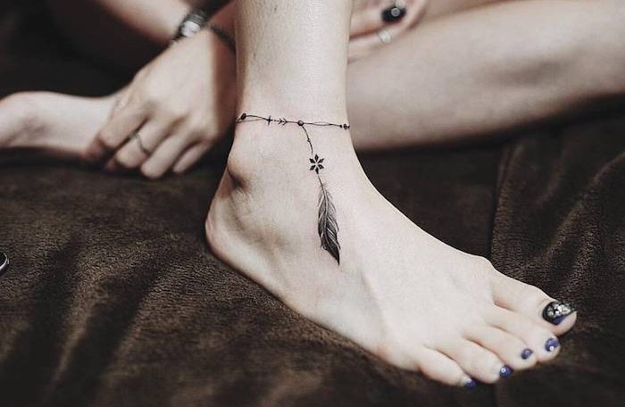 tatouage discret, dessin en encre imitation bracelet de cheville avec plume, manucure noire sur ongles longs