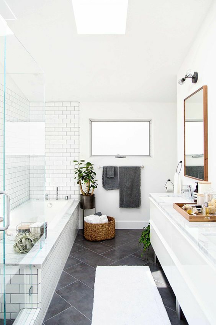 petite salle de bains avec baignoire et grand meuble en blanc pour le lavabo et pour ranger