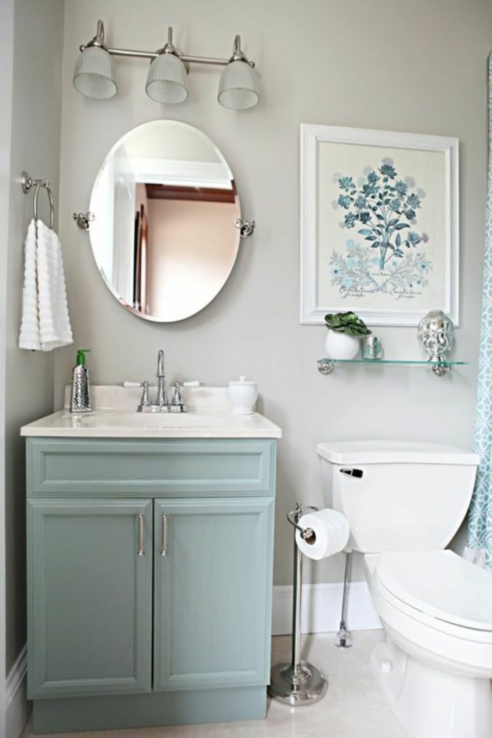 salle de bain très petite avec miroir ovale et tableau taille moyenne en blanc et bleu