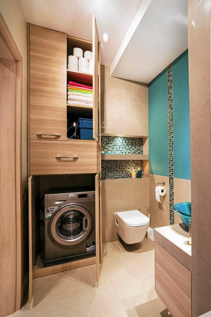 petit salle de bain avec des revetements en bois PVC clair et lave linge inséré dans le meuble