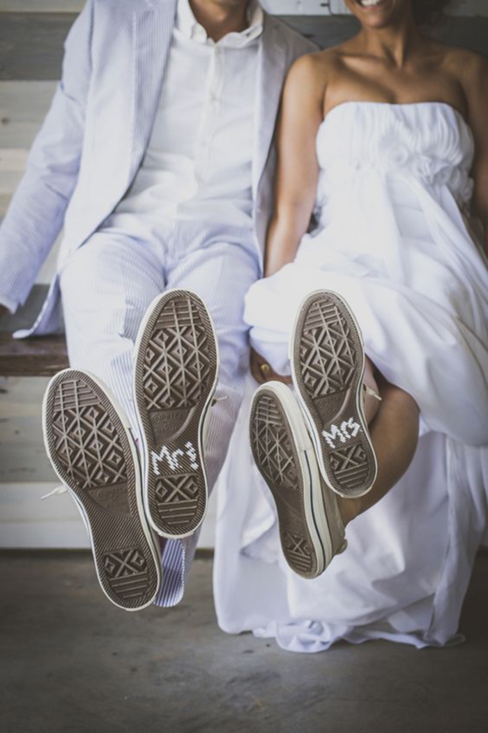 photo de couple décontracté avec leurs baskets de mariage en premier plan