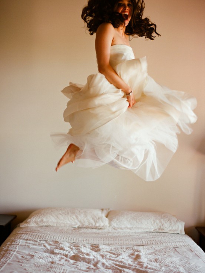 séance photo de boudoir originale, photo artistique de la mariée en train de sauter sur le lit