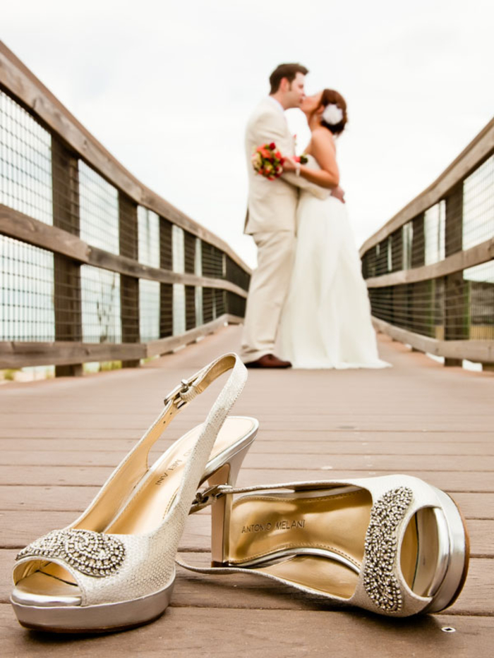 photo originale des chaussures de la mariée en premier plan, jolie photo de baiser 